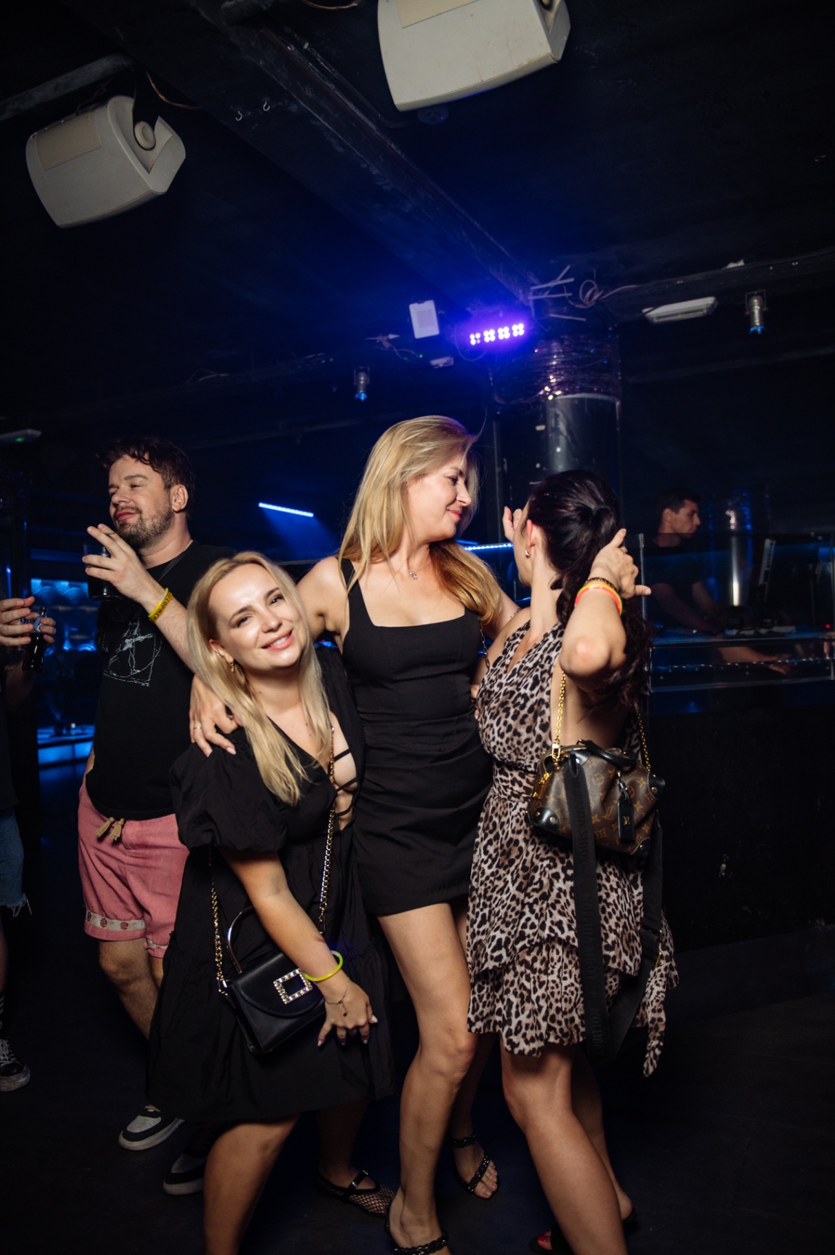 Friends dancing together in blue light on the floor