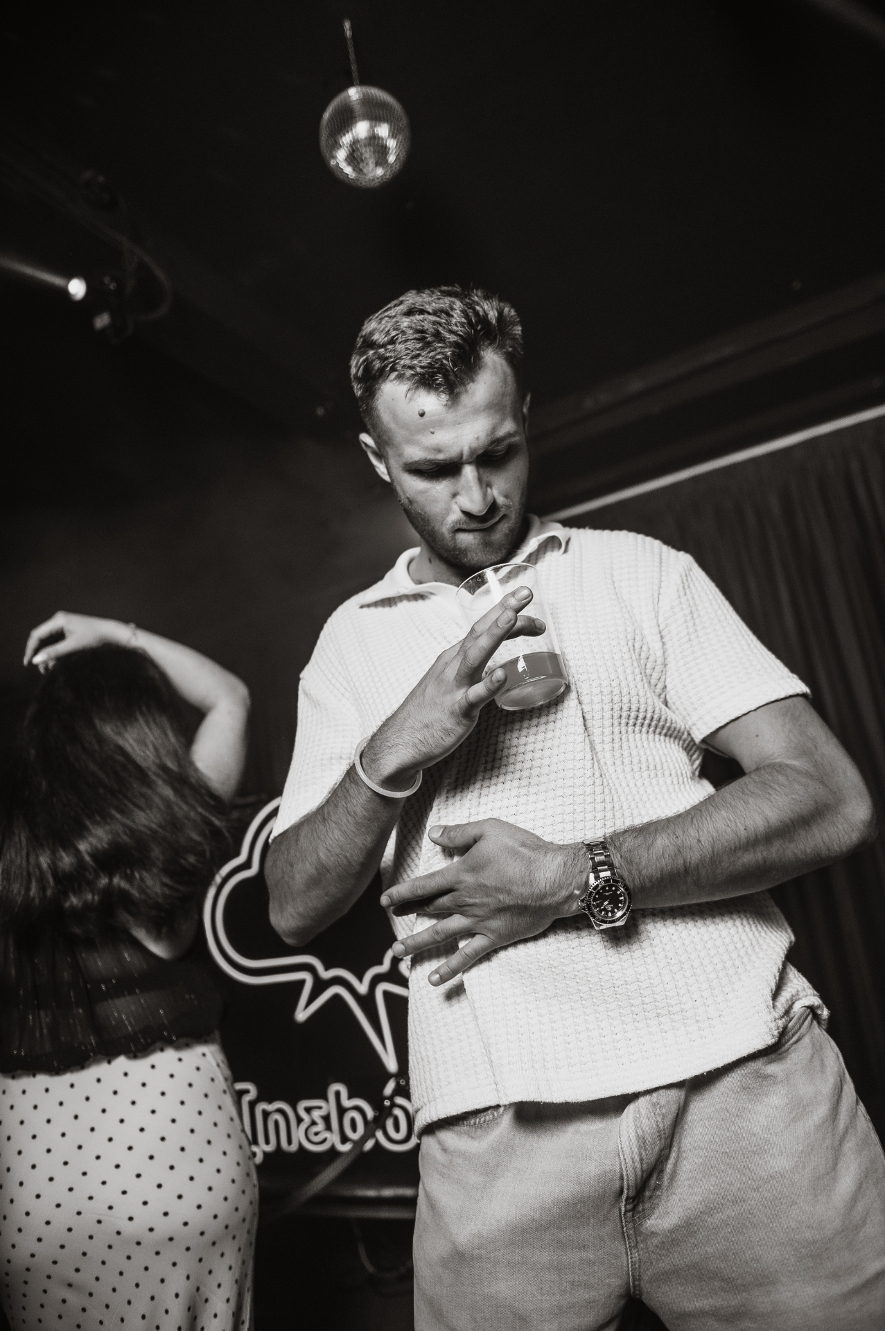 Guest dancing in front of the NEBO neon sign, black and white