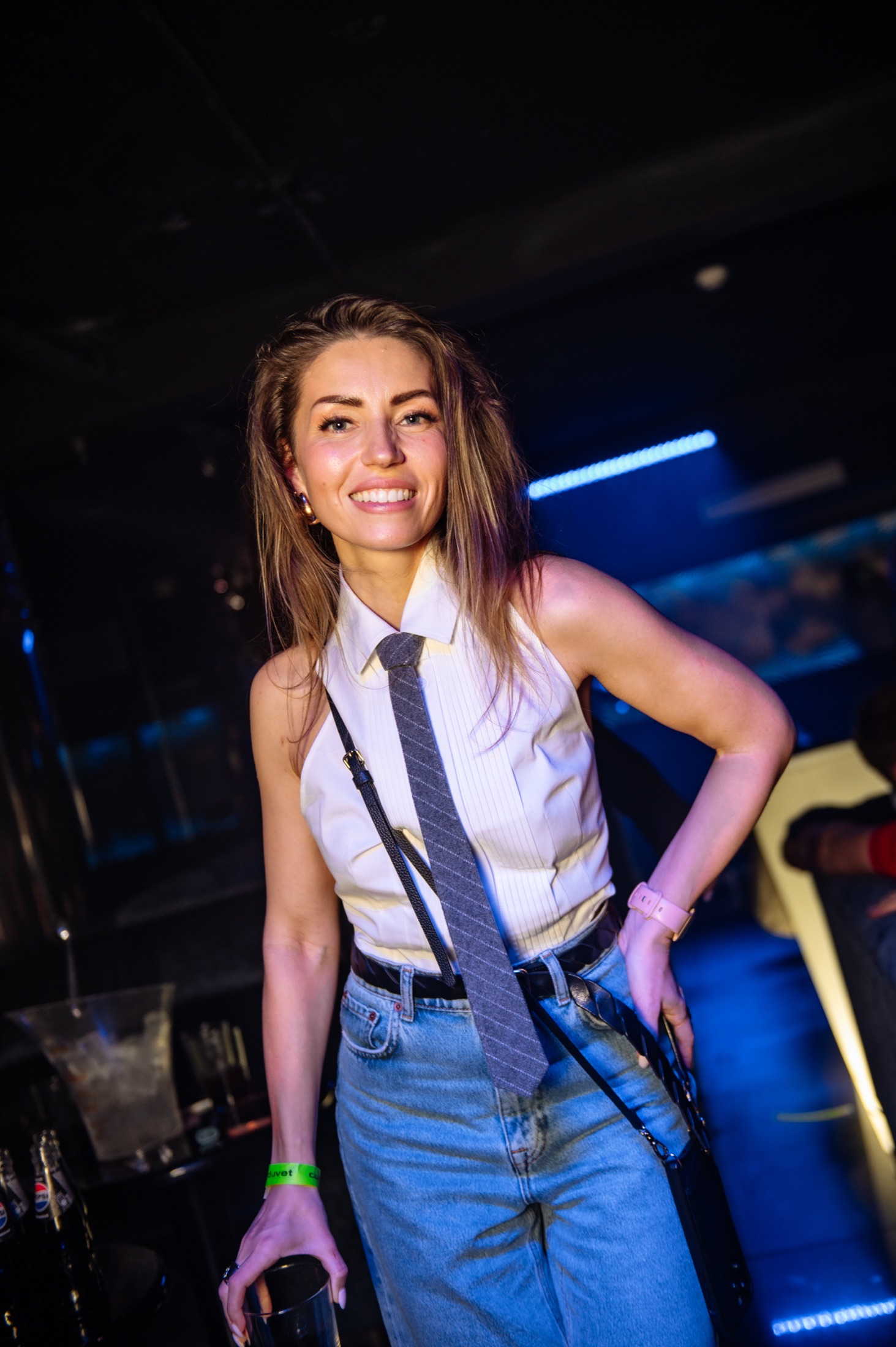 Smiling guest on the dance floor under blue club lights