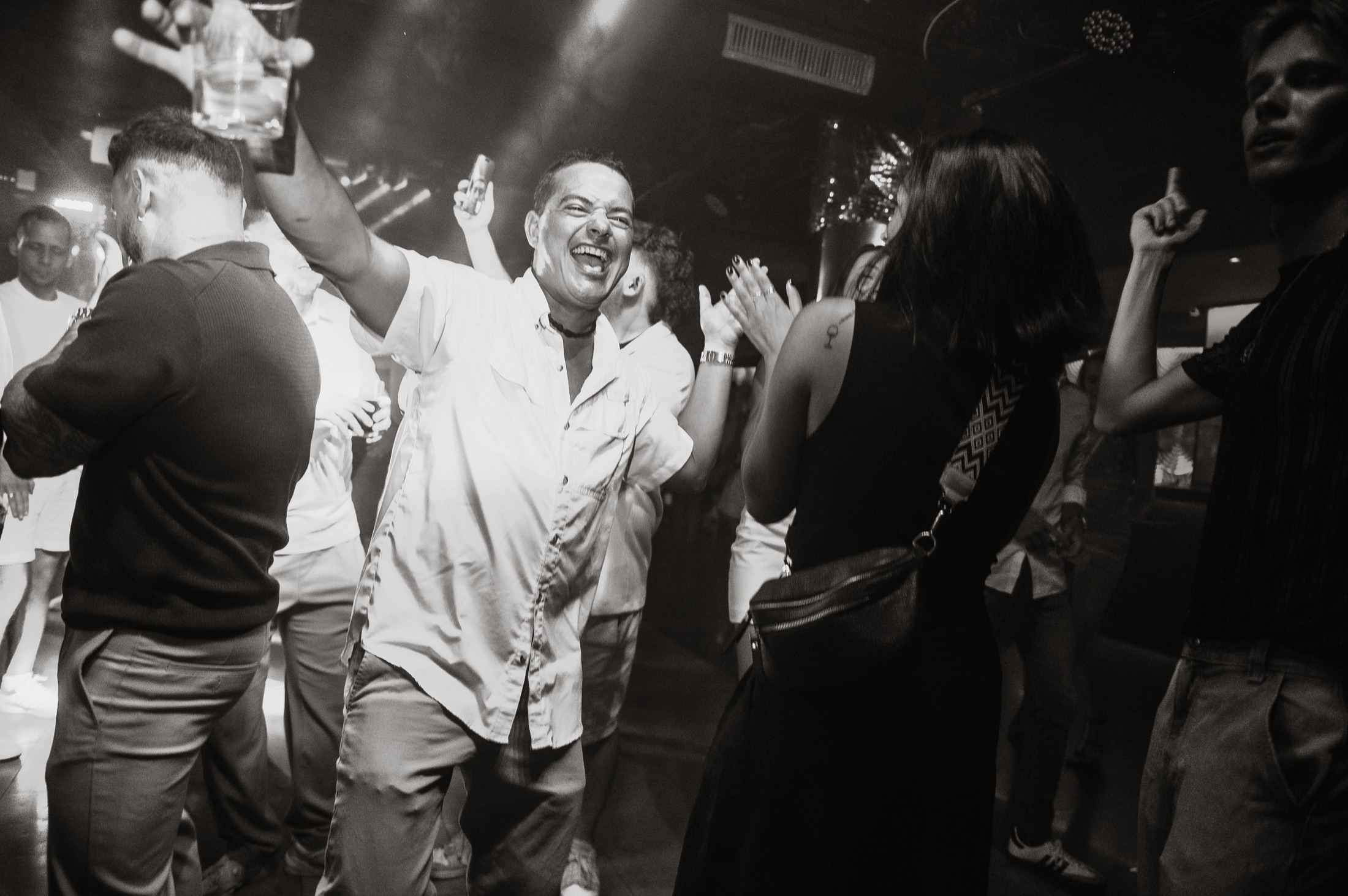 Guest celebrating in the middle of the crowd, photographed in black and white